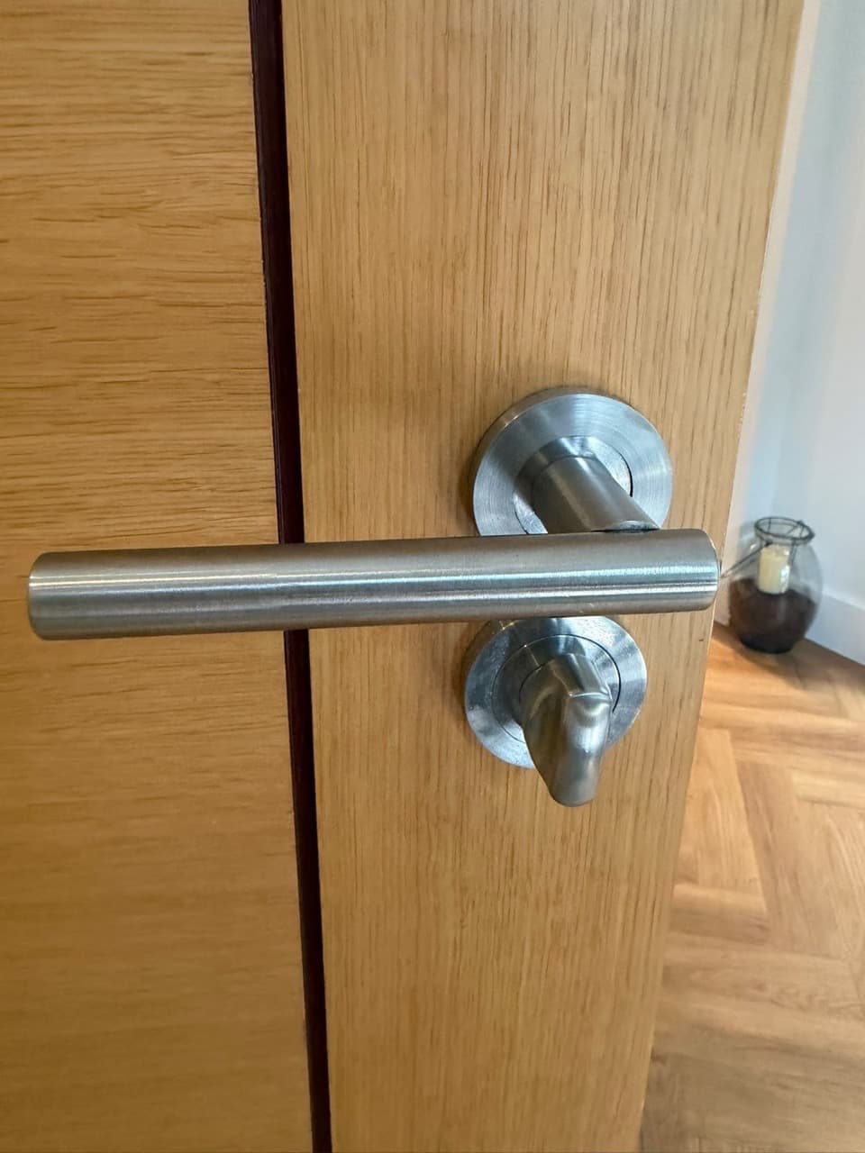 Brushed steel lever handle and thumbturn on an oak internal door